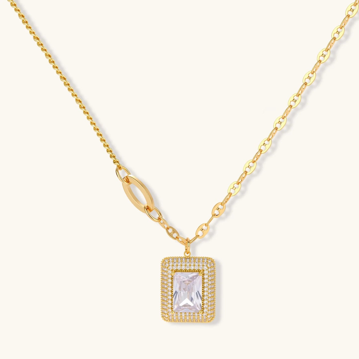 Gold-plated jewelry set with rectangular cubic zirconia stones in pave halo settings on cream background