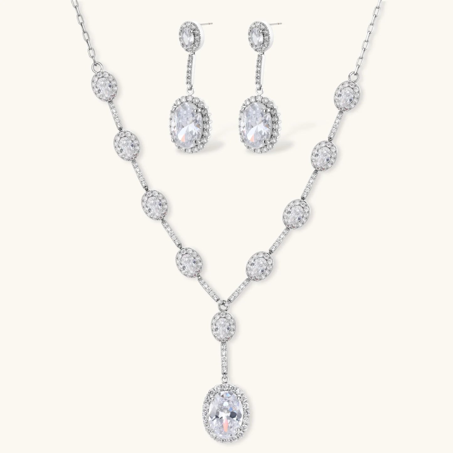 Elegant white gold plated jewelry set with oval cubic zirconia stones in halo settings, featuring Y-necklace and drop earrings.