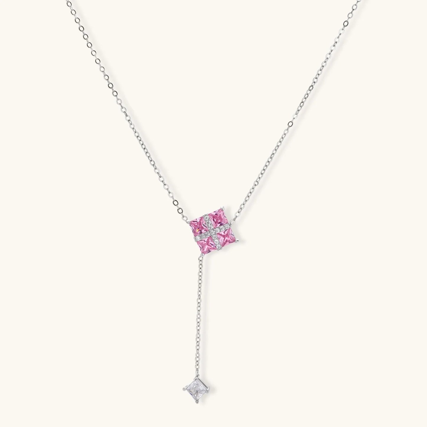 White gold plated jewelry set with pink cubic zirconia stones in geometric cross design, featuring Y-necklace and square stud earrings