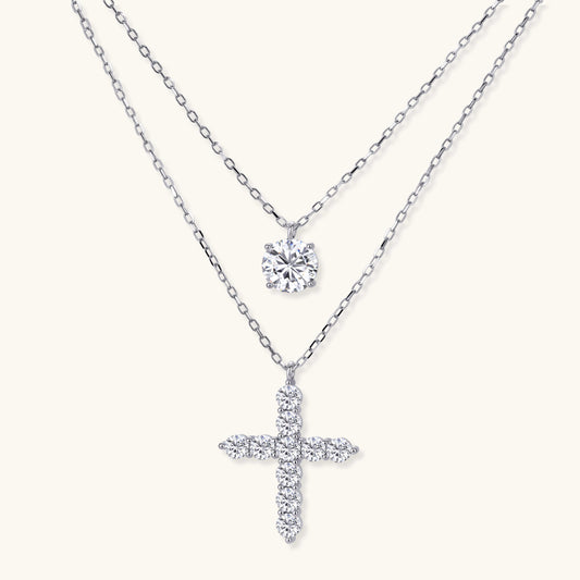 Two delicate sterling silver necklaces with moissanite stones - one solitaire pendant and one cross pendant on white background.