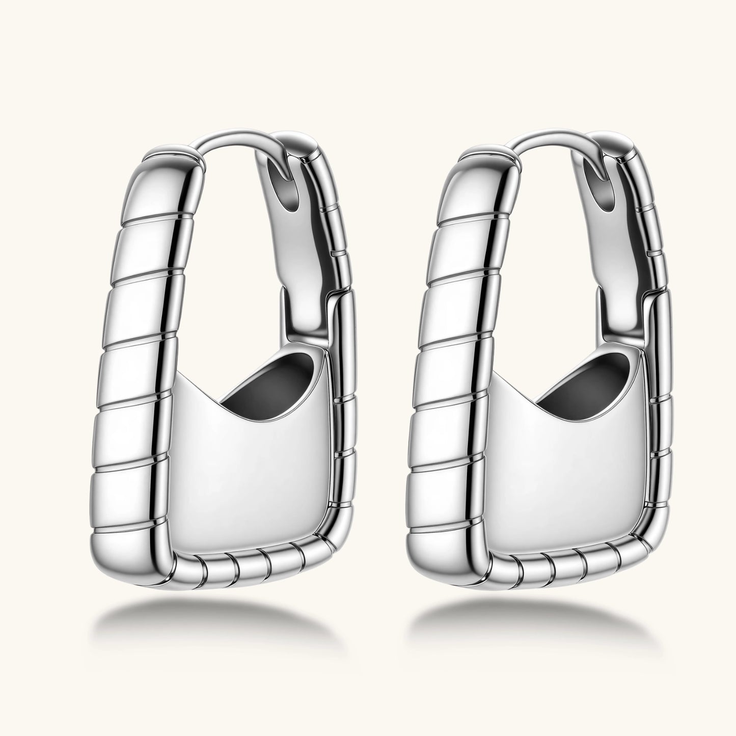 Close-up of platinum-plated sterling silver hoop earrings with horizontal textured grooves on white background.
