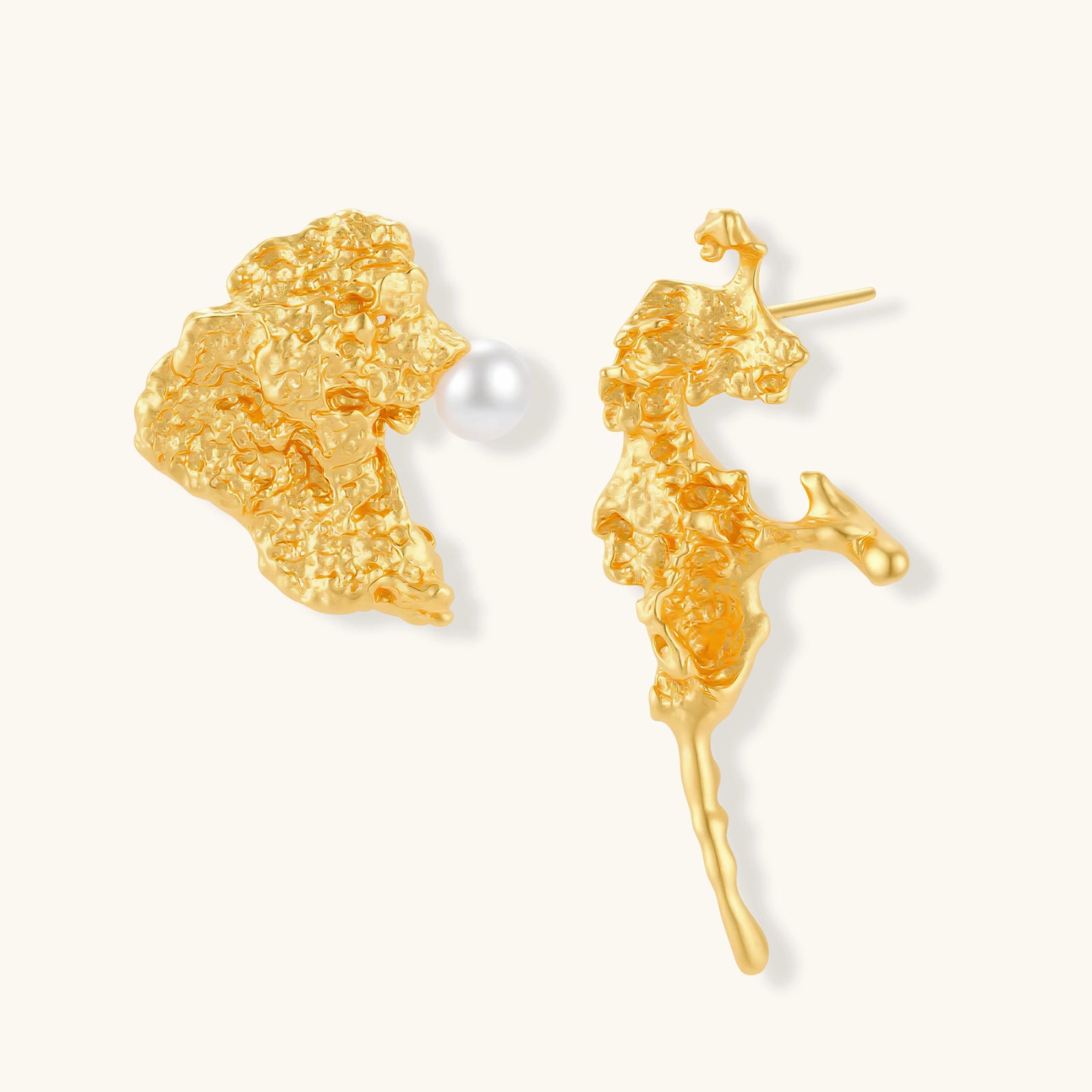 Textured gold stud earrings with coral-like organic surface, one featuring a freshwater pearl, displayed on white background.