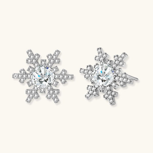 Sterling silver snowflake stud earrings with brilliant moissanite centers and intricate geometric patterns on cream background