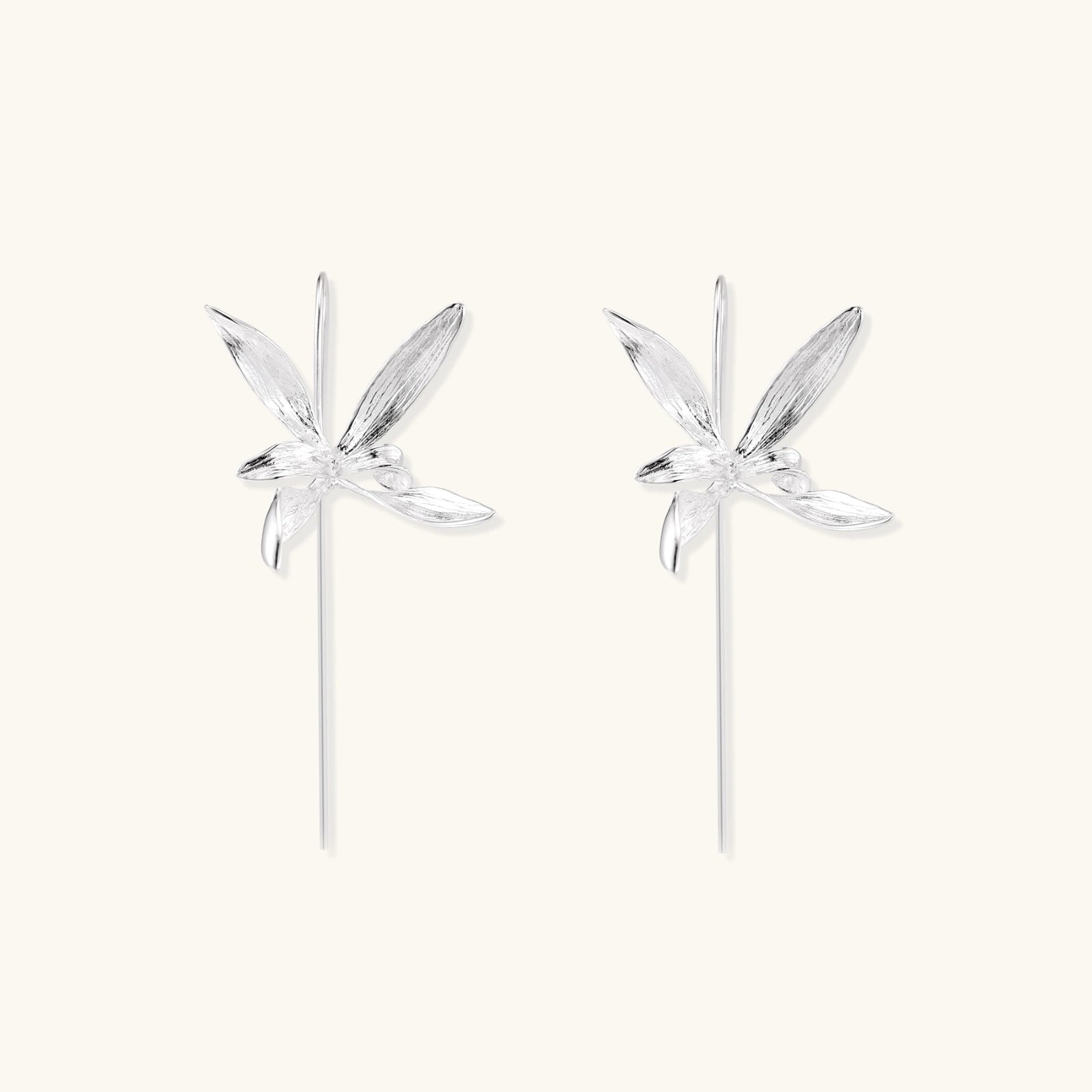 Delicate sterling silver dragonfly earrings with textured wings and curved threader hooks on white background
