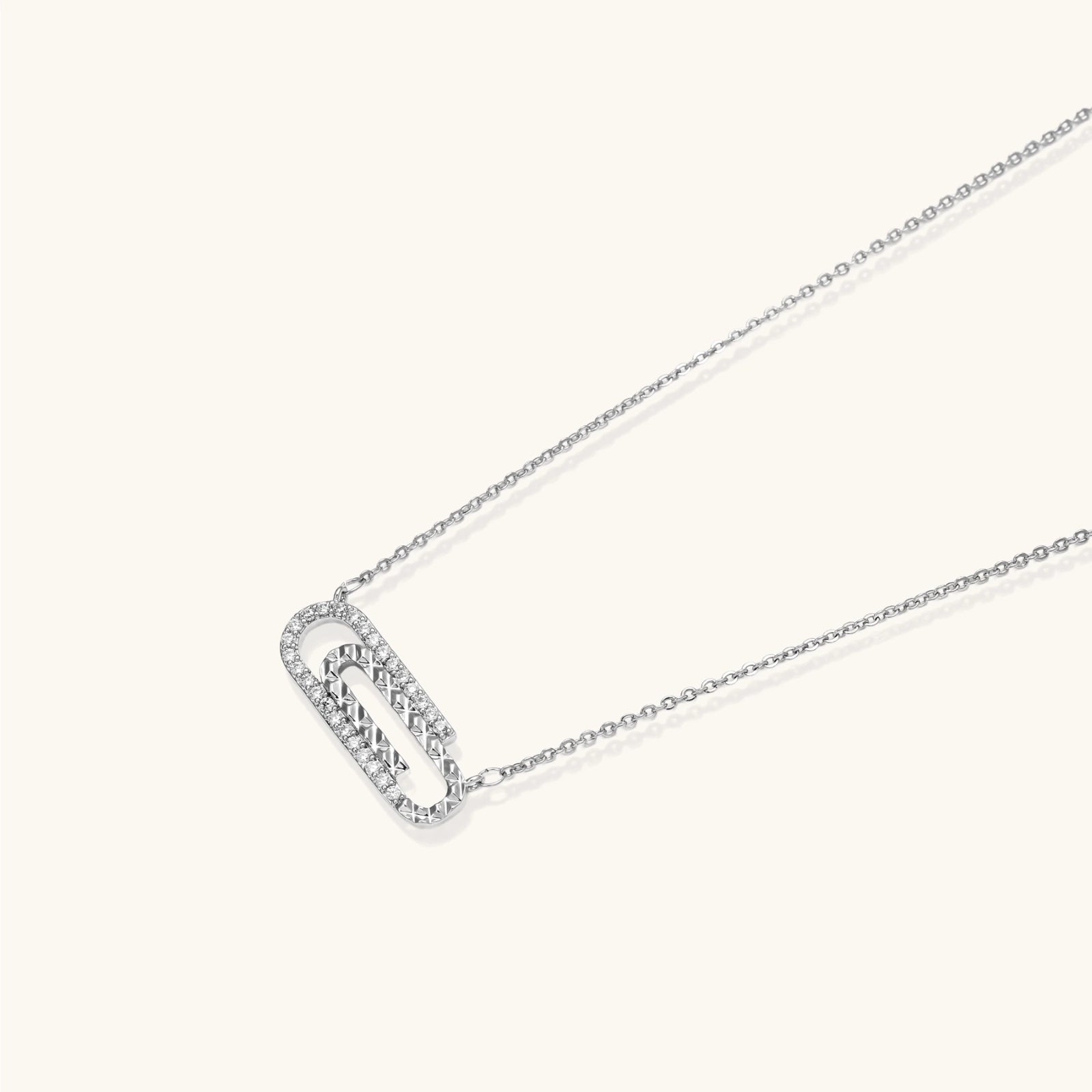 White gold plated necklace with dual-frame geometric pendant featuring crystal pavé border on pale background.