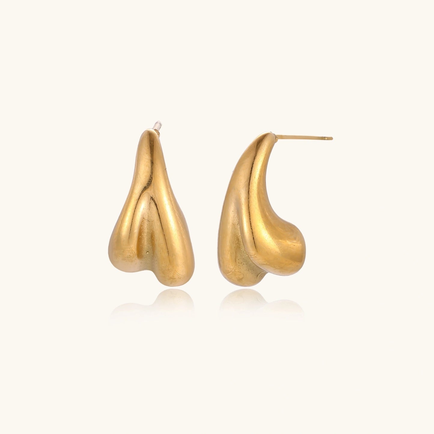 Organic sculptural gold stud earrings with fluid matte finish on cream background