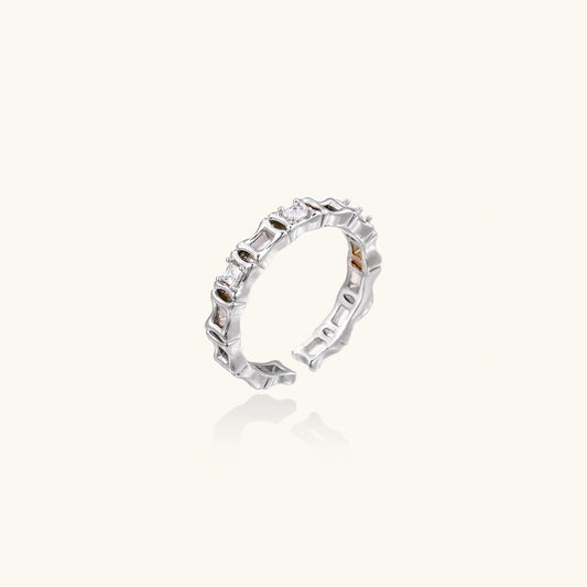 White gold plated ring with architectural lattice design and zirconia accents on cream background