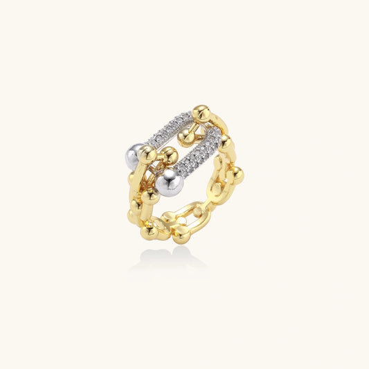 Triple-band gold ring with spherical bead chains and two crystal-pavé bars on cream background